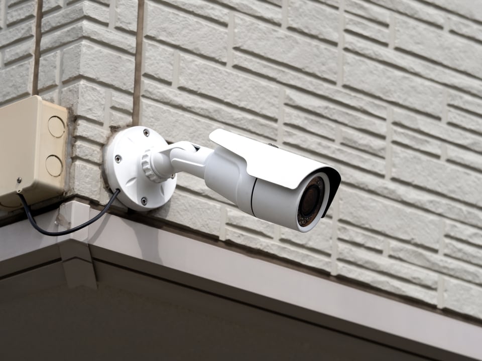 マンションの外壁に設置された24時間セキュリティシステムの防犯カメラ