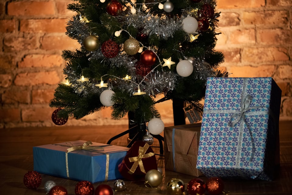 暖かなレンガ壁の室内に置かれたクリスマスツリーのオーナメントとプレゼント