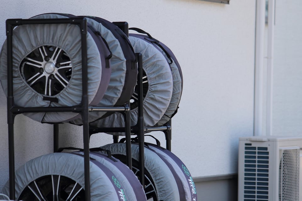 屋外のタイヤ置き場でタイヤラックに保管されているタイヤ