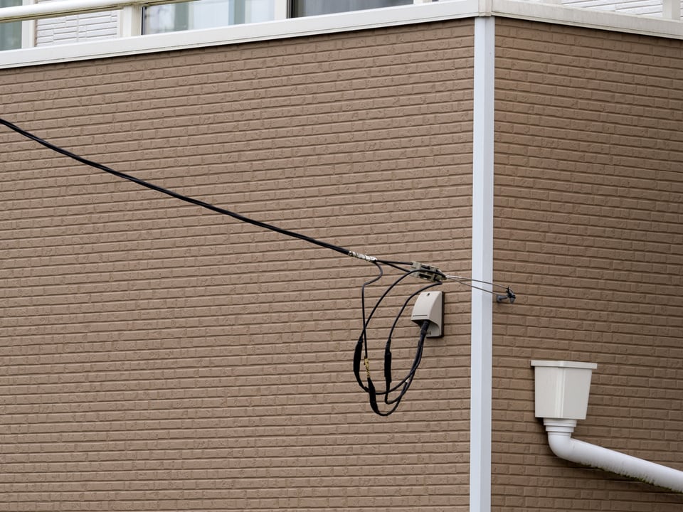 テレビ共聴アンテナから建物へと電線を引き込む工事を行った外壁部分