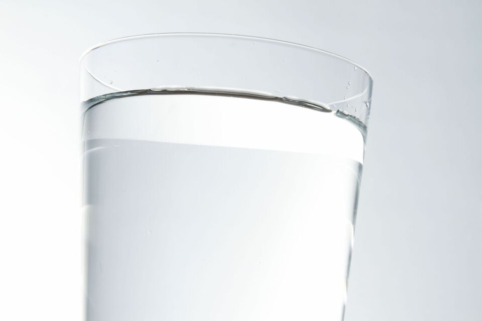 ガラスのコップに注がれた無色透明の液体トリクロロエチレン