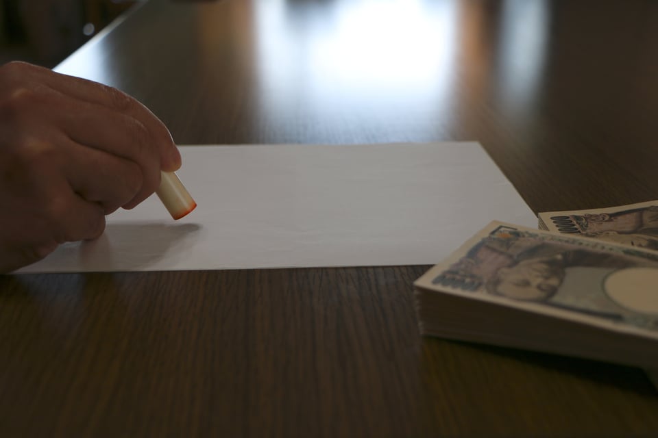 償却金などが記載された書類に捺印する様子