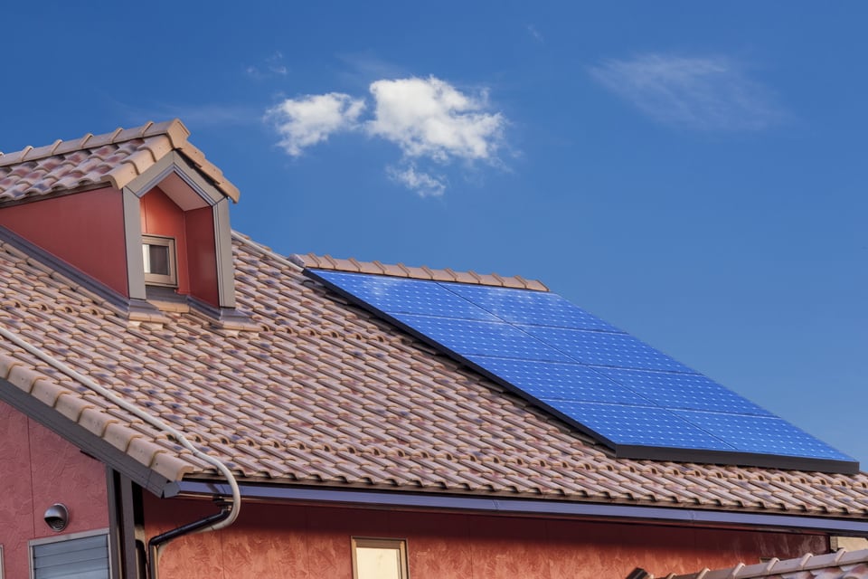 太陽光発電を行うソーラーパネルが屋根に設置されたレンガ色の一戸建て住宅