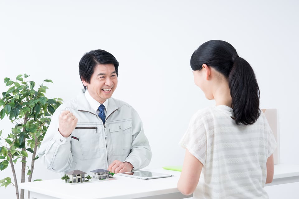 不動産業者と専属専任媒介契約を結ぶ女性