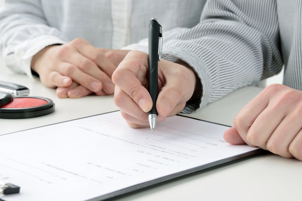 権利金についての詳細が記載された契約書にサインをしている男性