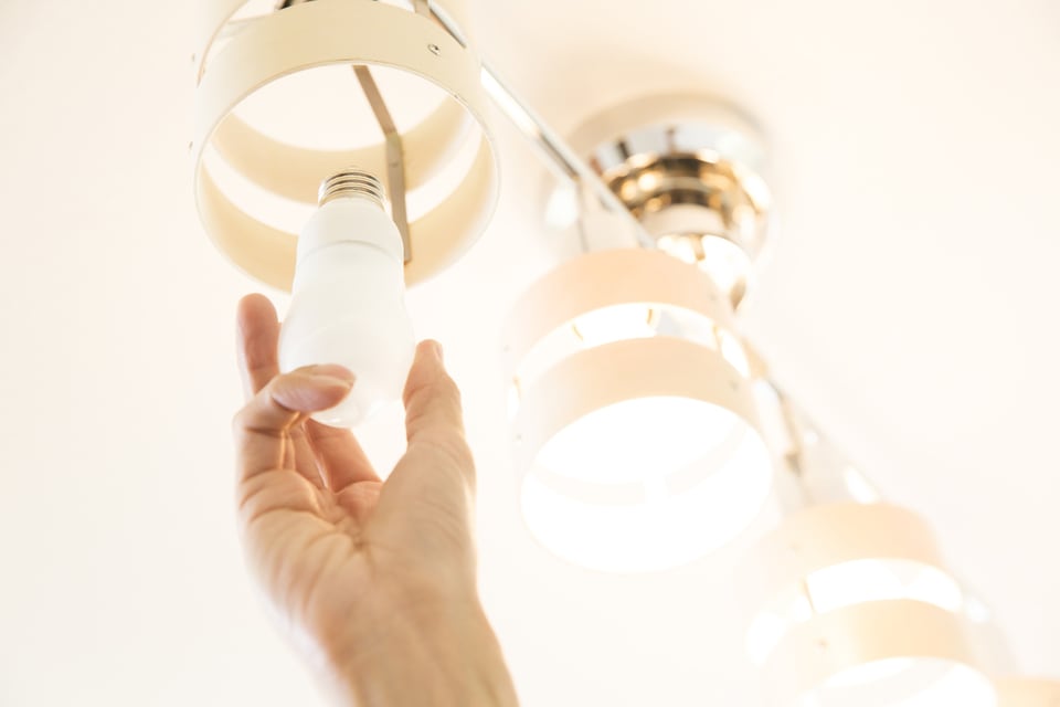 省エネ性能のある電球を取り付けている男性