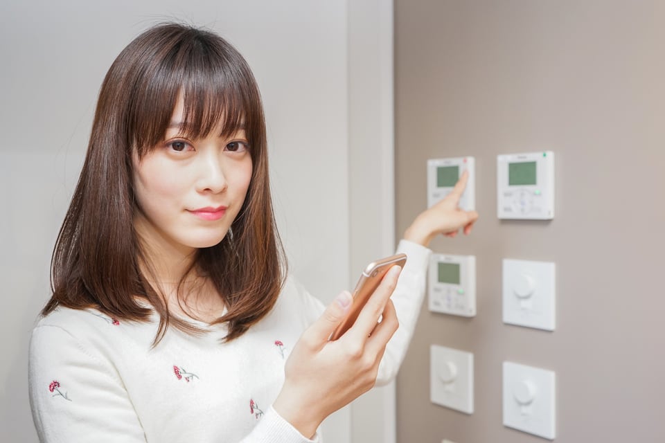 IoT技術を駆使した蓄エネのスイッチを操作する女性