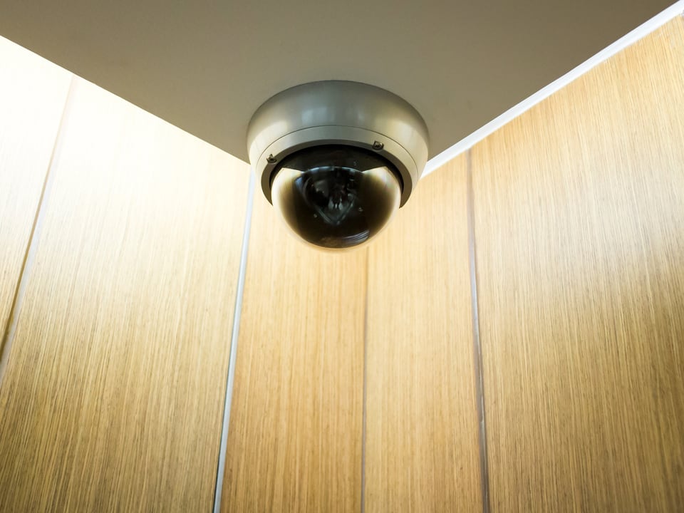 エレベーター内に取り付けられたドーム型の防犯カメラ