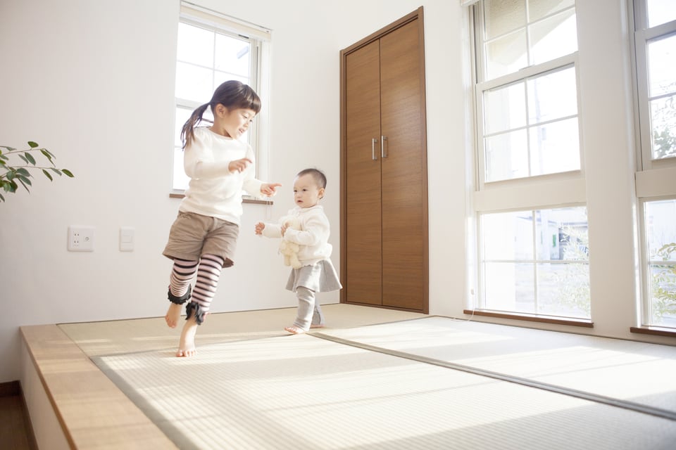 リビングの一角に設置した縁付き畳の和モダン空間で遊ぶ子どもたち