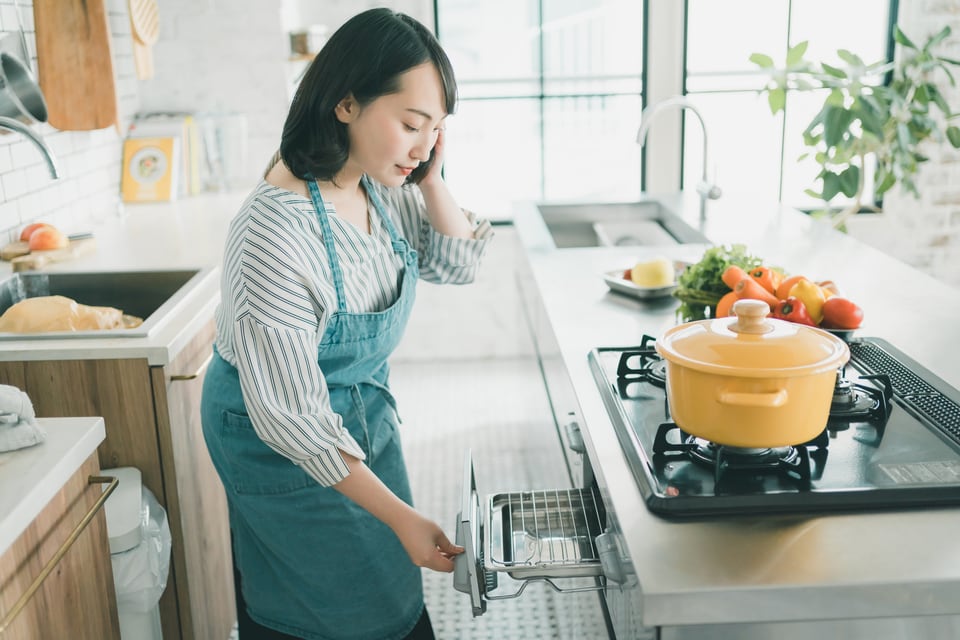 グリルを使用して料理をする女性