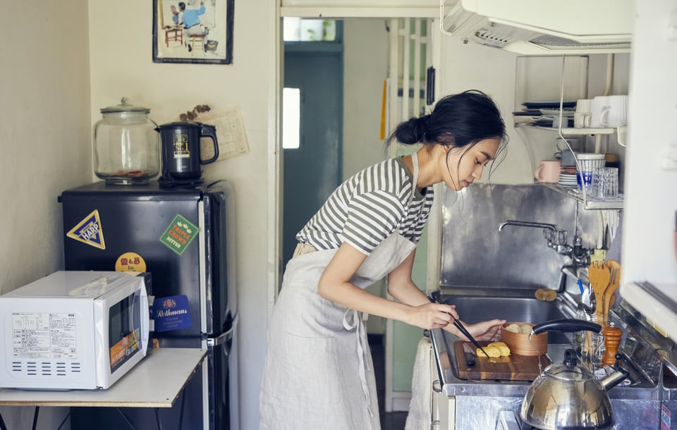 出勤前にクローズドキッチンで弁当を作っている女性