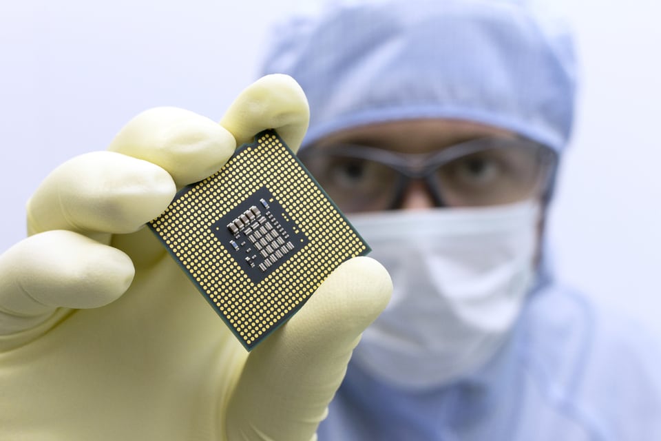 シリコンを原料とした半導体チップを手に取る男性技術者