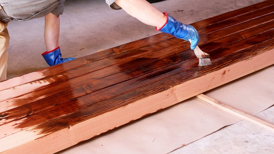 DIYで木材にエチルベンゼンを含む防腐剤を塗布する男性