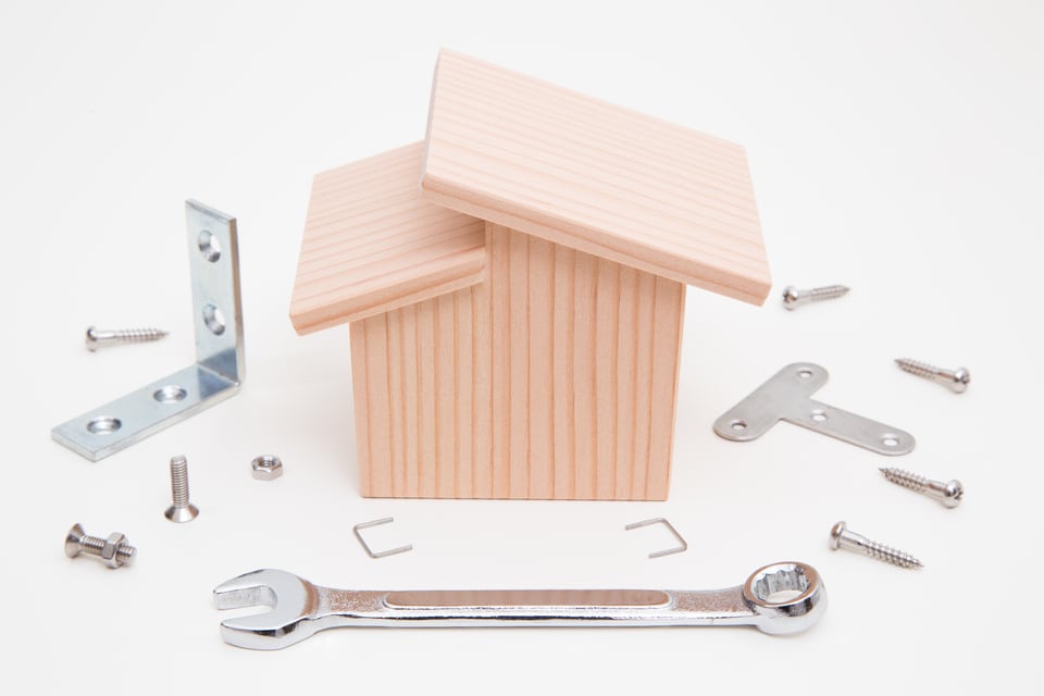 構造材をイメージした建築用の金具や工具と家の模型