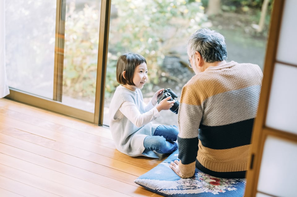 縁甲板でできた縁側でカメラの使い方を教えてもらう孫