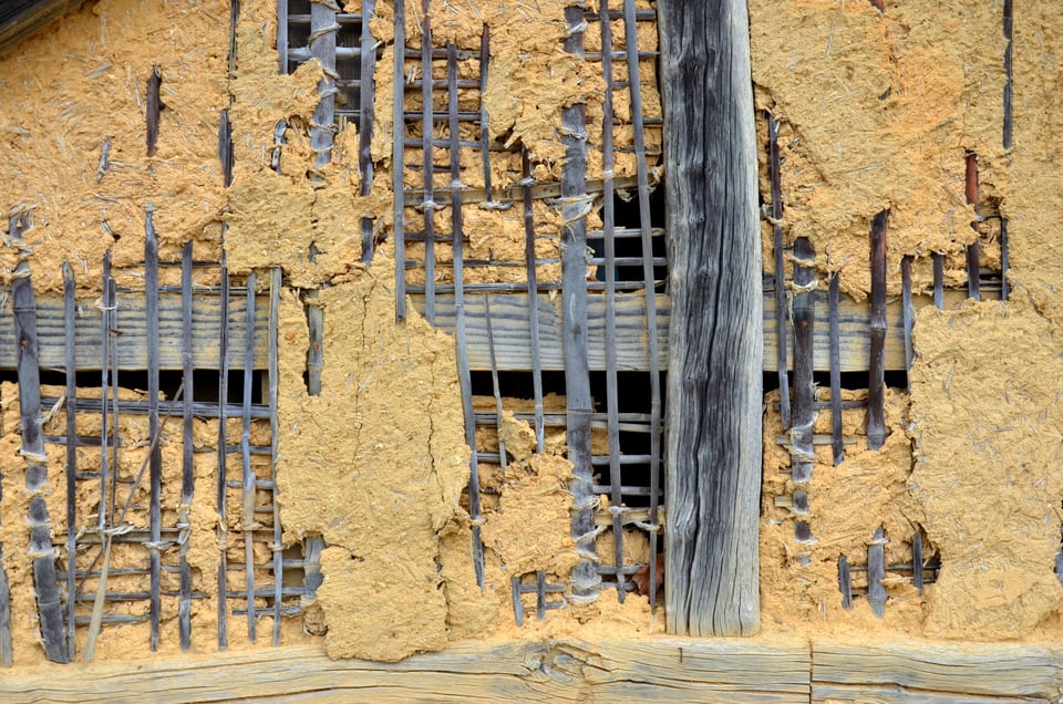 古い日本家屋の土壁からむきだしになった竹小舞