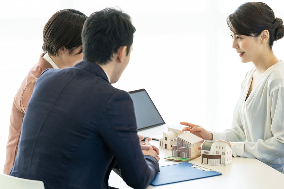 現在の申込状況やマーケット状況について会話している不動産業者と売主