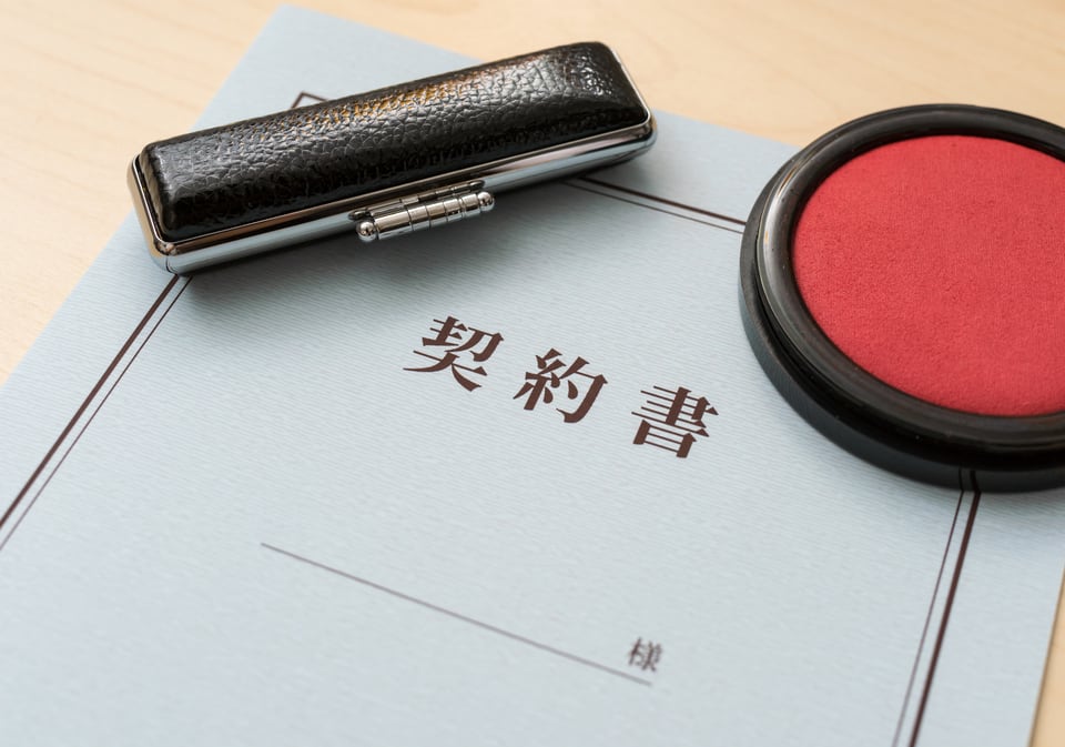 解約のため契約書の上に置かれた朱肉と印鑑