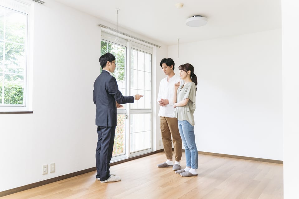 定期借家の内見をする若い夫婦と不動産会社スタッフ