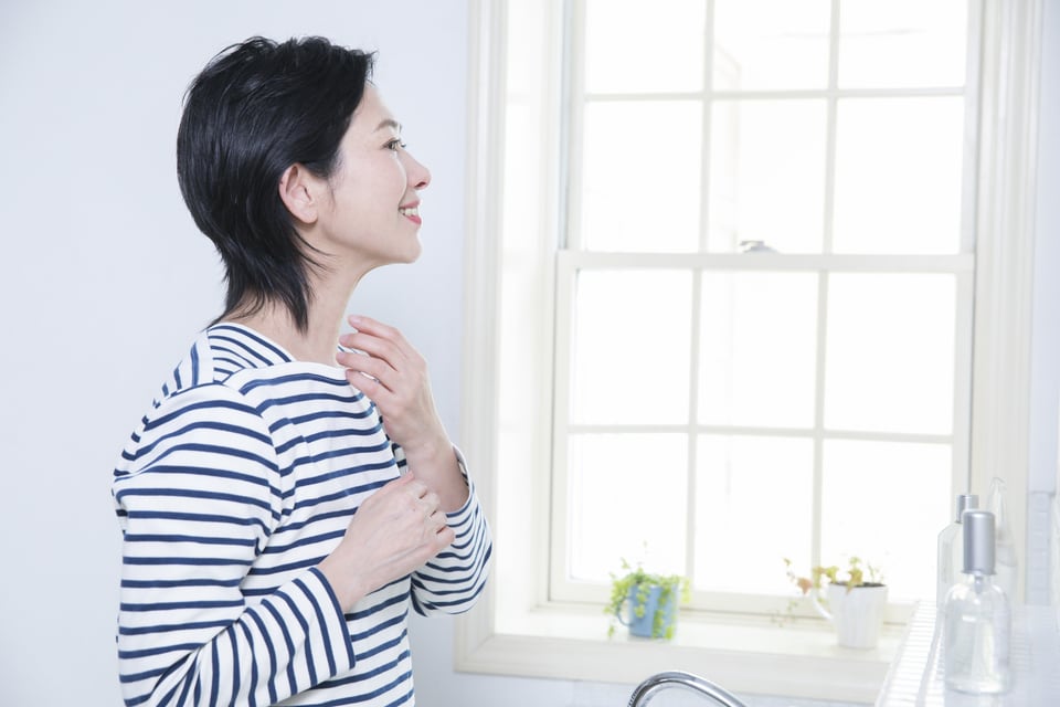 上げ下げ窓のある洗面所で身なりを整える女性