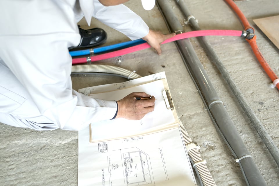 マンション長期修繕計画により給水設備を修繕する準備を行う作業員