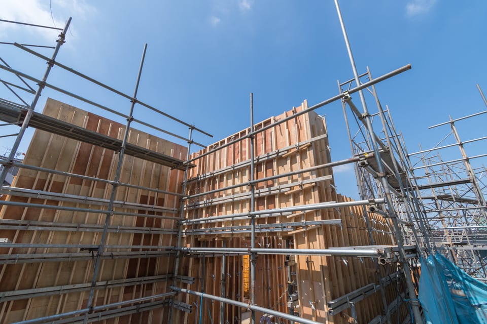足場が組まれた、間柱が見える木造建築