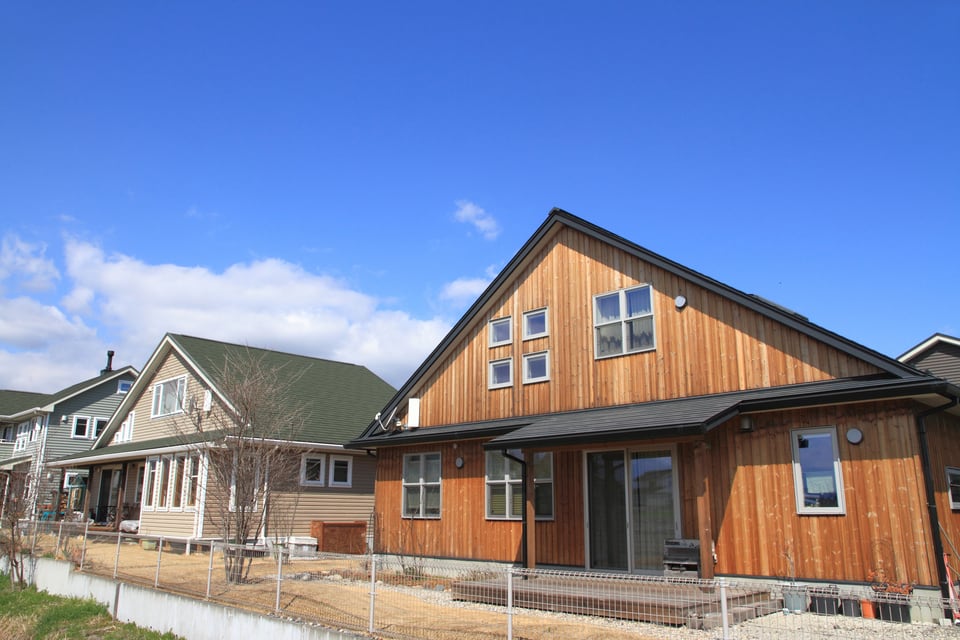 アメリカンスタイルの特徴の一つである大きな屋根や白い窓枠がある戸建て住宅