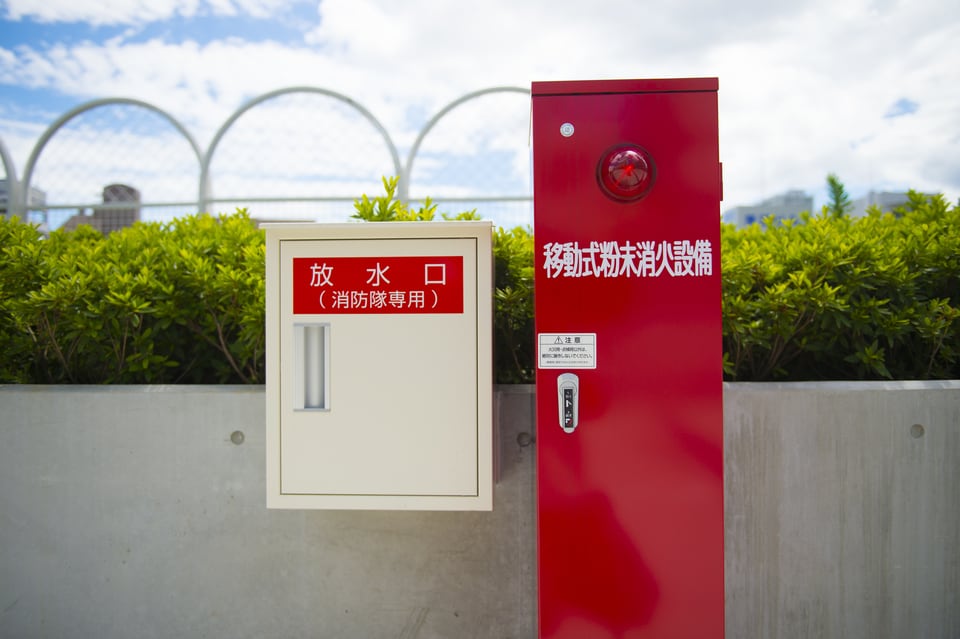屋外に設置された移動式の粉末消火設備と放水口