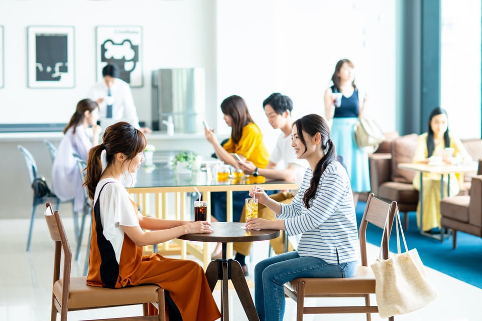 カフェテーブルをはさみくつろぐ人々