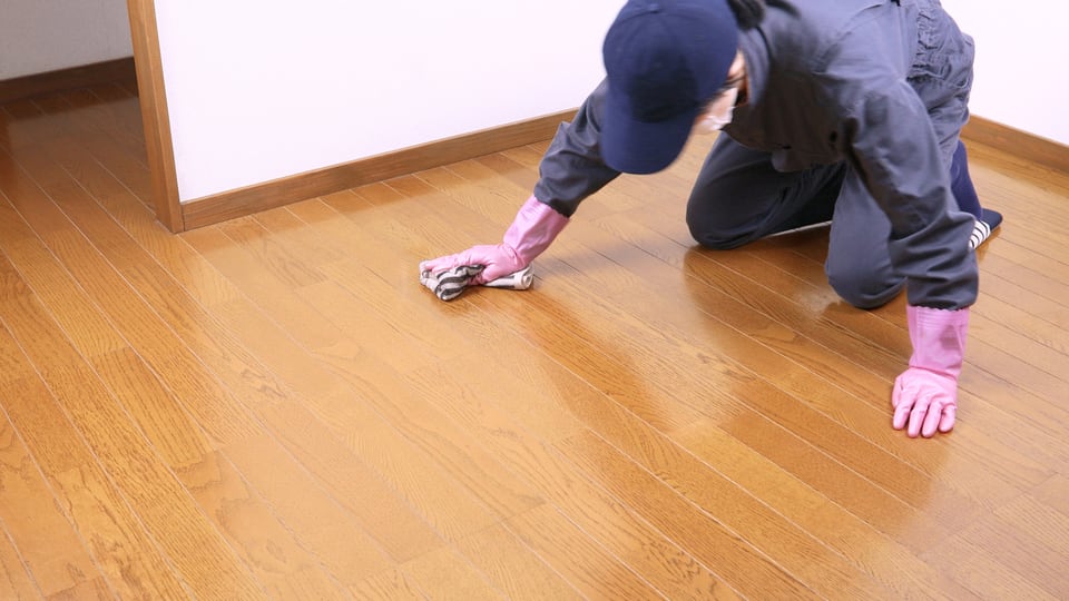 コーティング加工を施したフローリングの清掃を行う作業員