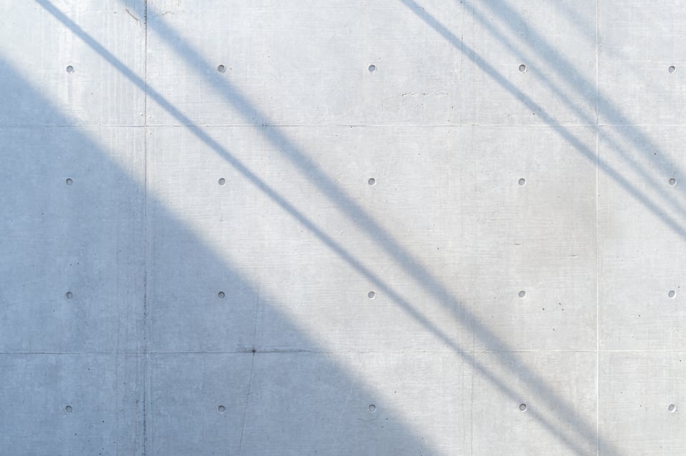 光と影が交差するコンクリート打ち放しの外壁