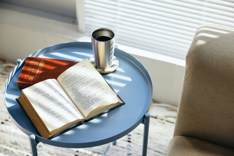 読みかけの本とコーヒーが置かれたサイドテーブル