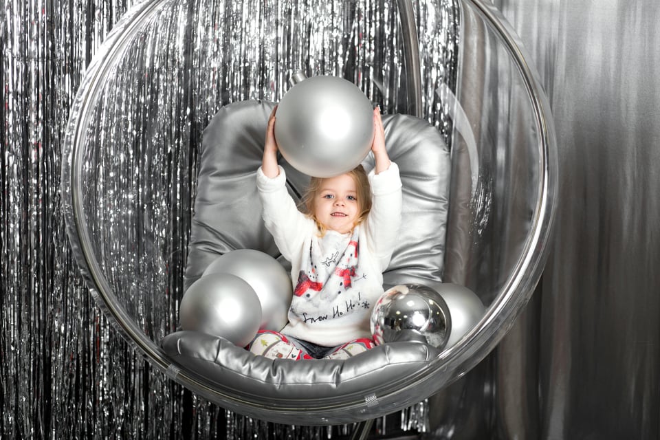 バブルチェアに座ってボール遊びをする子ども