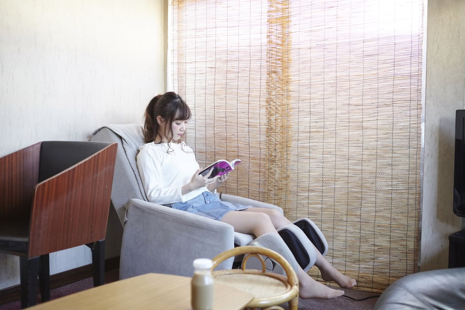 マッサージチェアでくつろぐ若い女性