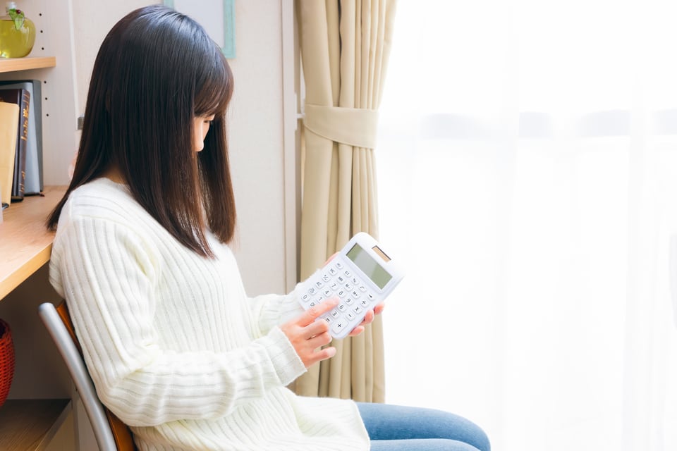検討中の物件と家賃相場を比べる女性