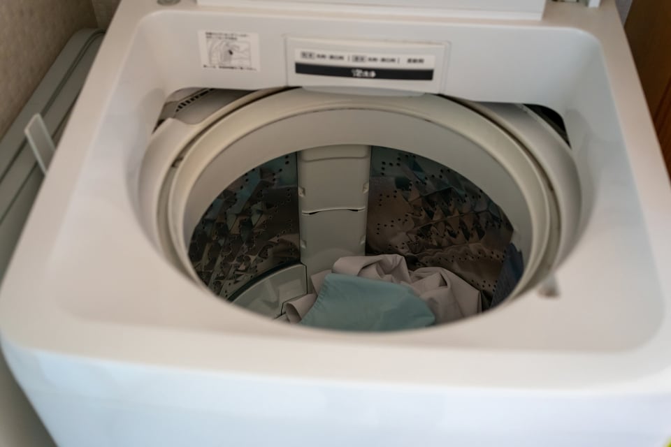 洗濯物が入った縦型洗濯乾燥機