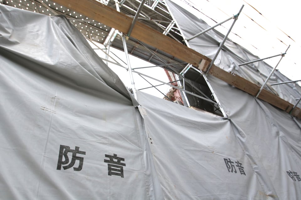 防音幕を使い騒音対策に取り組む建築現場