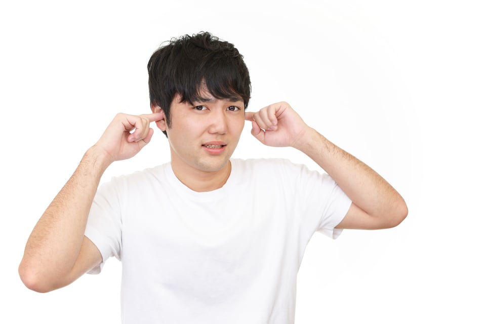 騒音対策をしていない工事現場から発する音に不快に感じる男性