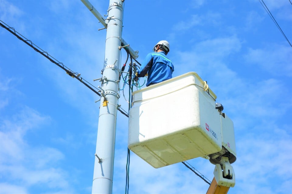 電柱の電気工事を行うリフトに乗った男性