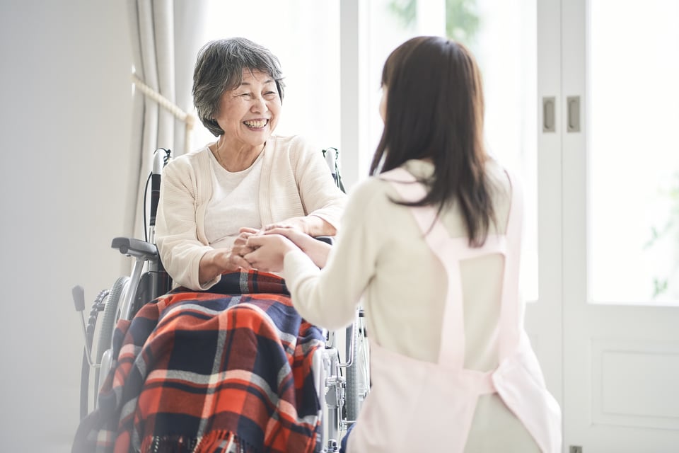 グループホームの職員と会話する高齢の入居者