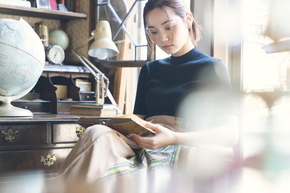 ビューローの前で読書をする若い女性
