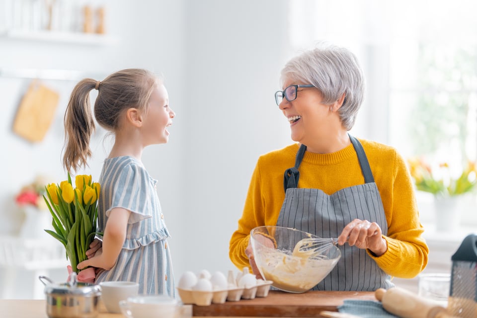 ユニバーサルキッチンで楽しく調理をしている高齢者とその孫