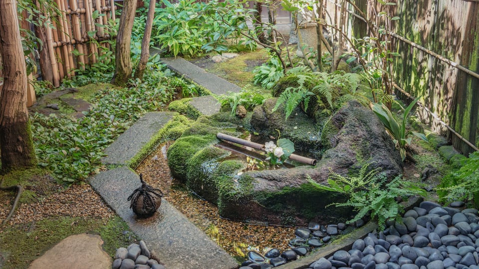 青みがかった玉石が敷かれている日本庭園