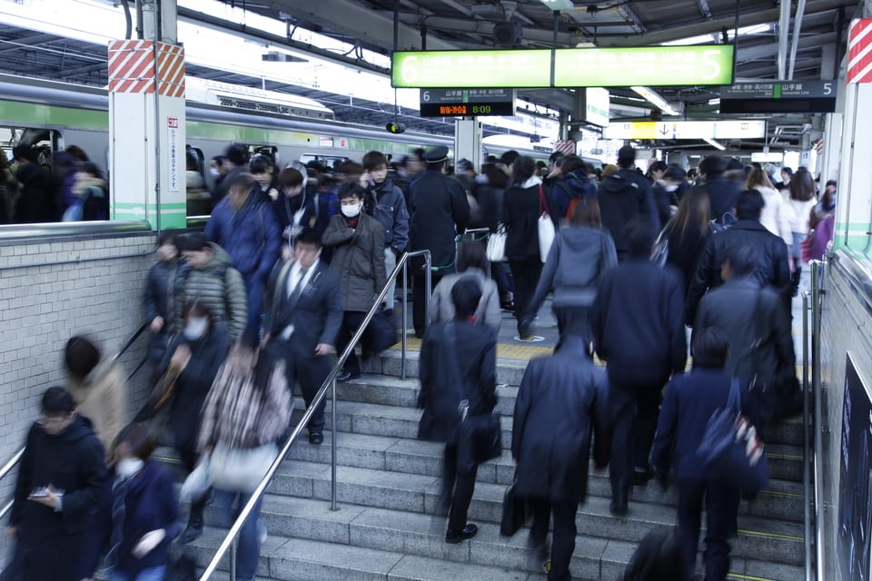 通勤ラッシュの中で足早に移動する人々の波
