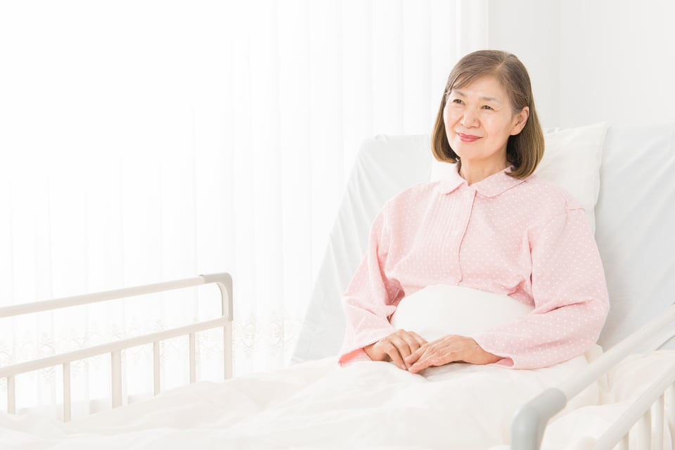 介護用の特殊寝台を利用する高齢女性