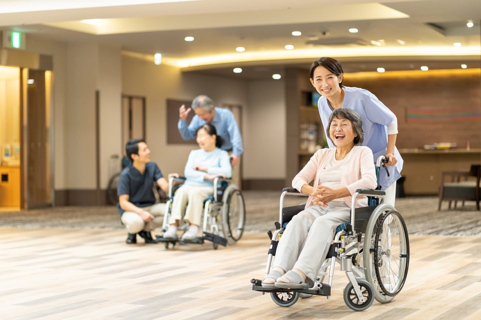 レクリエーションを楽しむ特定施設の入居者と職員