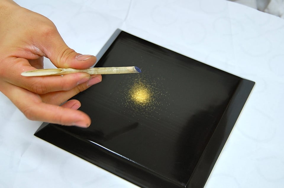 粉筒から金粉を振りかけ作る研出蒔絵