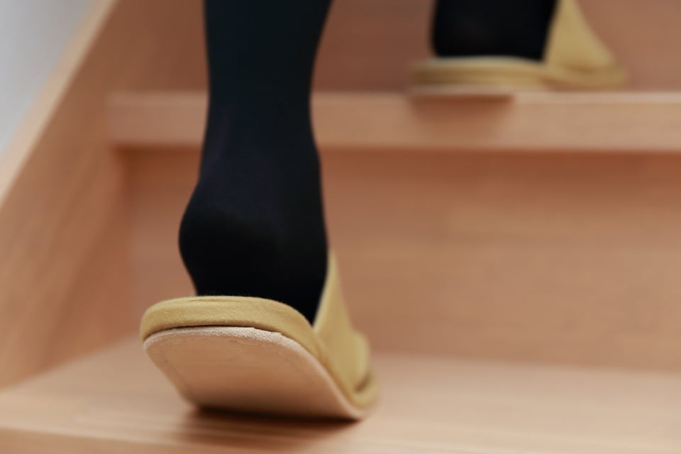住宅の側桁階段を登っている女性