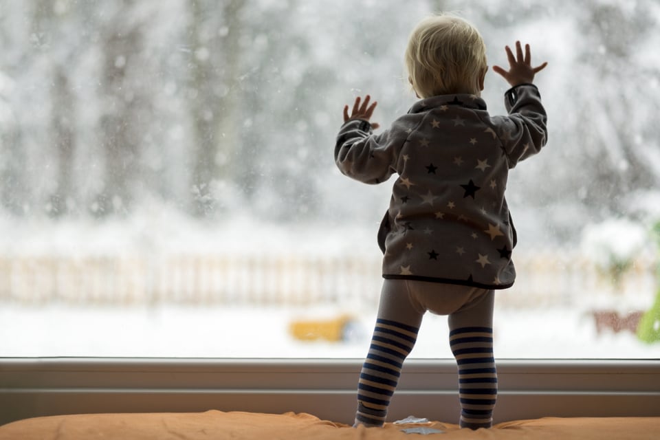 断熱窓から雪をながめている子供