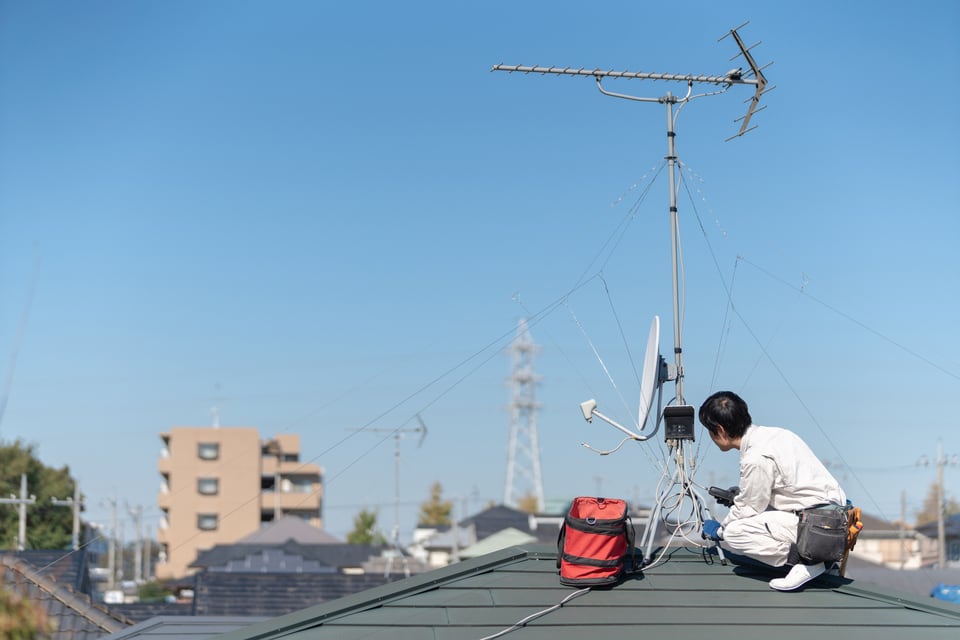電波障害が生じたためアンテナ工事をしている作業員